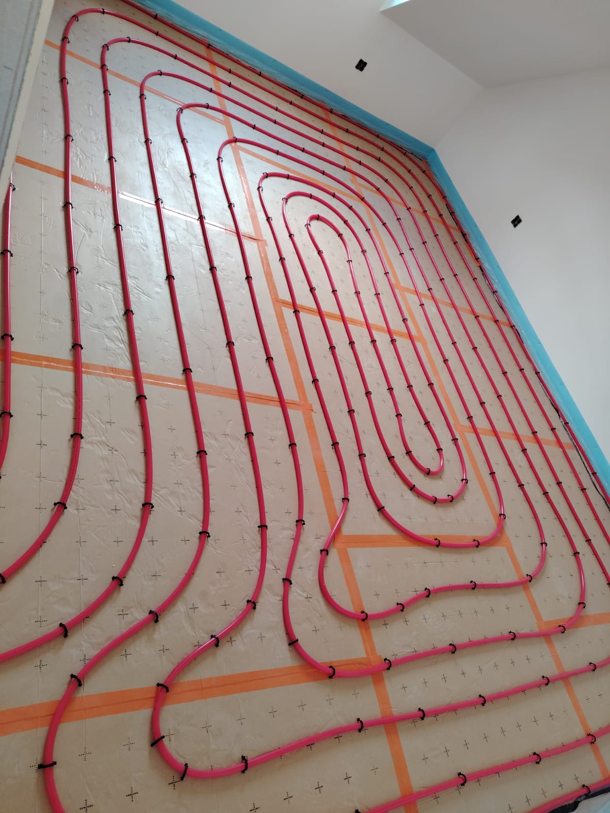 Plancher chauffant mural — boucles PER serrées sur plots